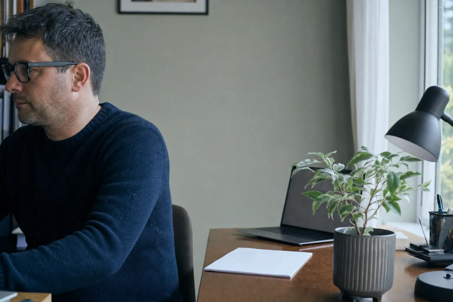 A small home office with a laptop and a face-down statement
